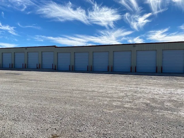 Row of white roll-up doors on the storage building at RV Storage Tulsa